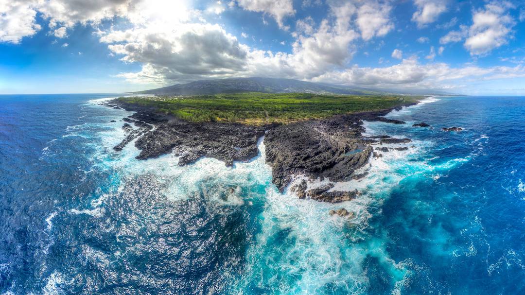 Îlot rocheux et lagon turquoise vus par drone